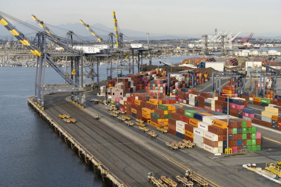 AN AERIAL SHOT OF A PORT DOCK, SHOWING CRANES, DOCKS AND CONTAINERS