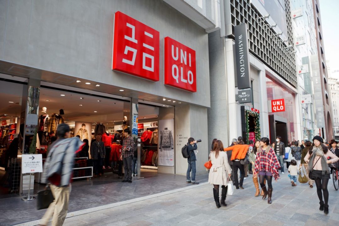 SHOPPERS PASS A UNIQLO STORE FRONT ON A BUSY PEDESTRIAN STREET