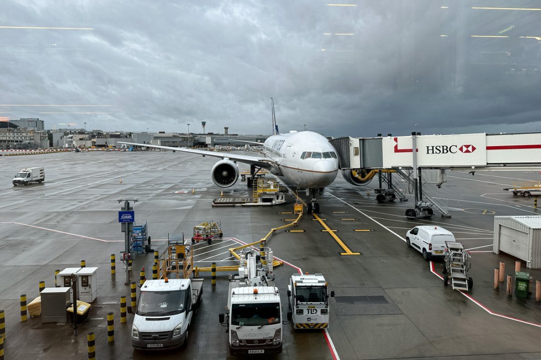 AN AIRPLANE SITS ON THE TARMAC OF AN AIRPORT UNDER GLOOMY SKIES