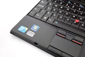 A CLOSE UP VIEW OF A BLACK COMPUTER SITTING ON A WHITE DESKTOP