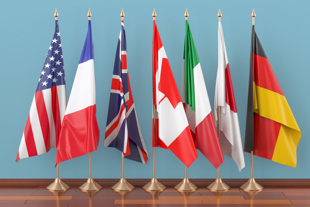 Flags of all members of the G7 Group in front of a blue wall, 3D rendering