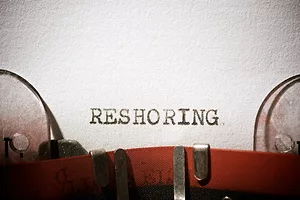 The word "RESHORING" is written on a typewriter. Photo: iStock.com/pedrosala