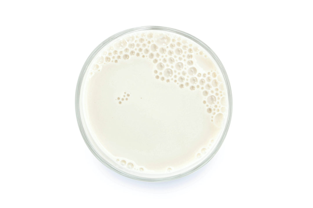 An aerial view of a glass of milk in front of a white background. Photo: iStock.com/SmileStudioAP