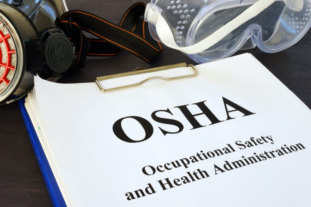 A pile of documents sits on top of a clipboard with the top piece of paper reading "OSHA Occupational Safety and Health Administration." Photo: iStock.com/designer491