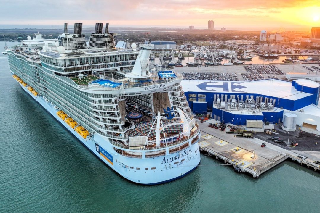 A GIANT CRUISE SHIP DOCKS AT A PORT TERMINAL
