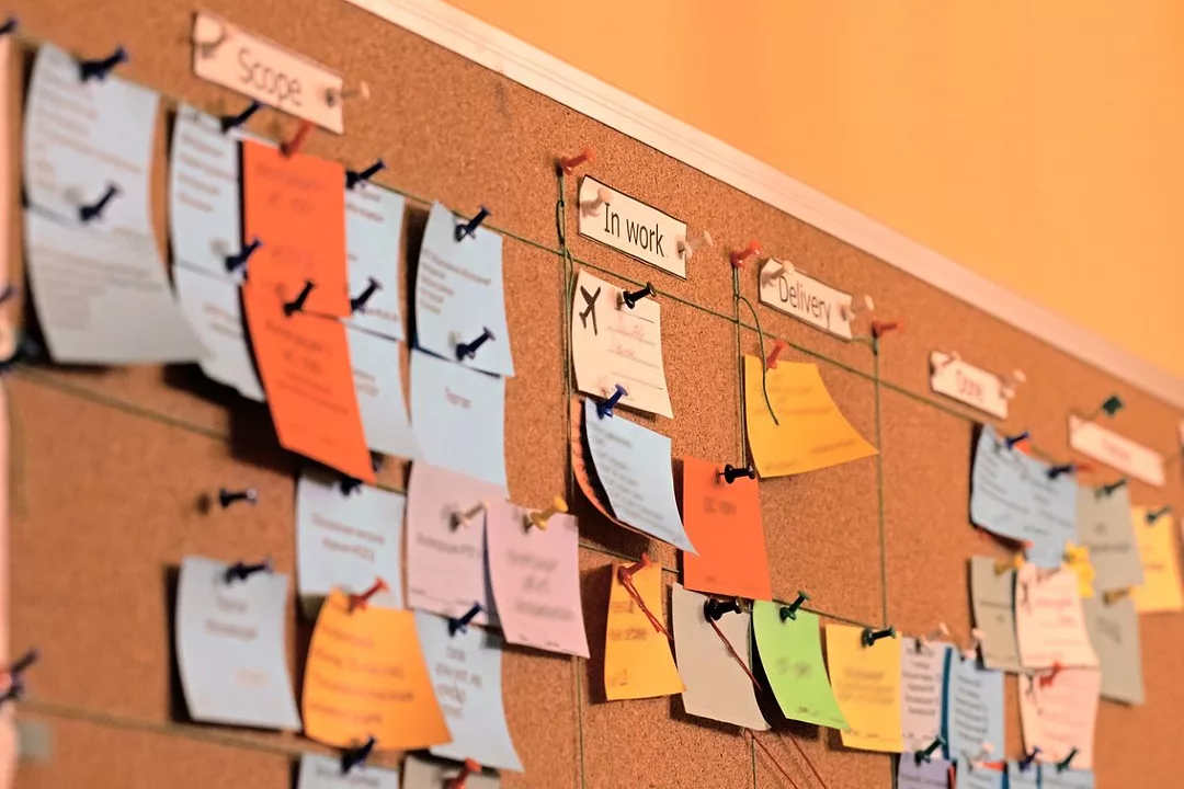Close up of a task, office bulletin board, covered in stickers.