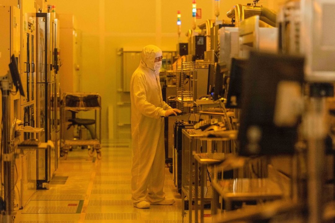 A worker is in a clean room for silicon semiconductor wafer manufacture at the Newport Wafer Fab. Photo: Bloomberg