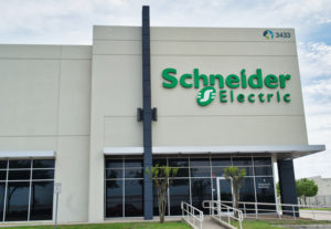 THE EXTERIOR OF A SCHNEIDER ELECTRIC OFFICE BUILDING IN FRONT OF A CLOUDY SKY.