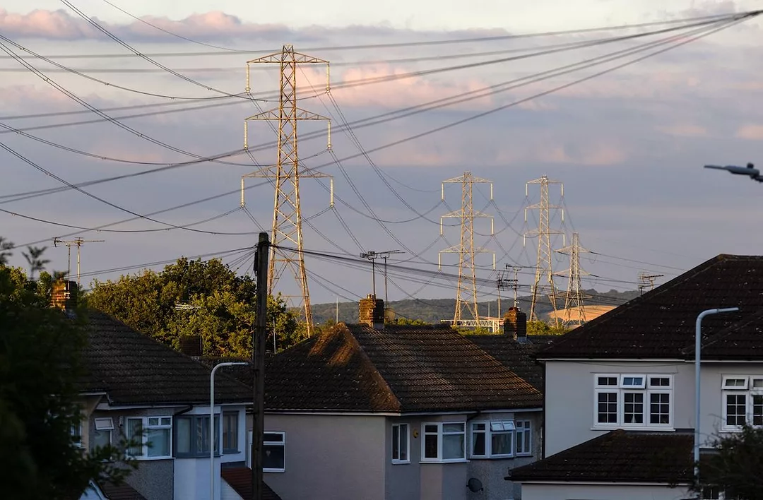 Electricity transmission towers can be seen near residential homes