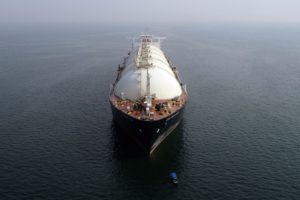 A LARGE LIQUIFIED NATURAL GAS TANKER IS TRAVELING ACROSS THE OCEAN.