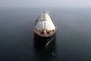 A LARGE LIQUIFIED NATURAL GAS TANKER IS TRAVELING ACROSS THE OCEAN.