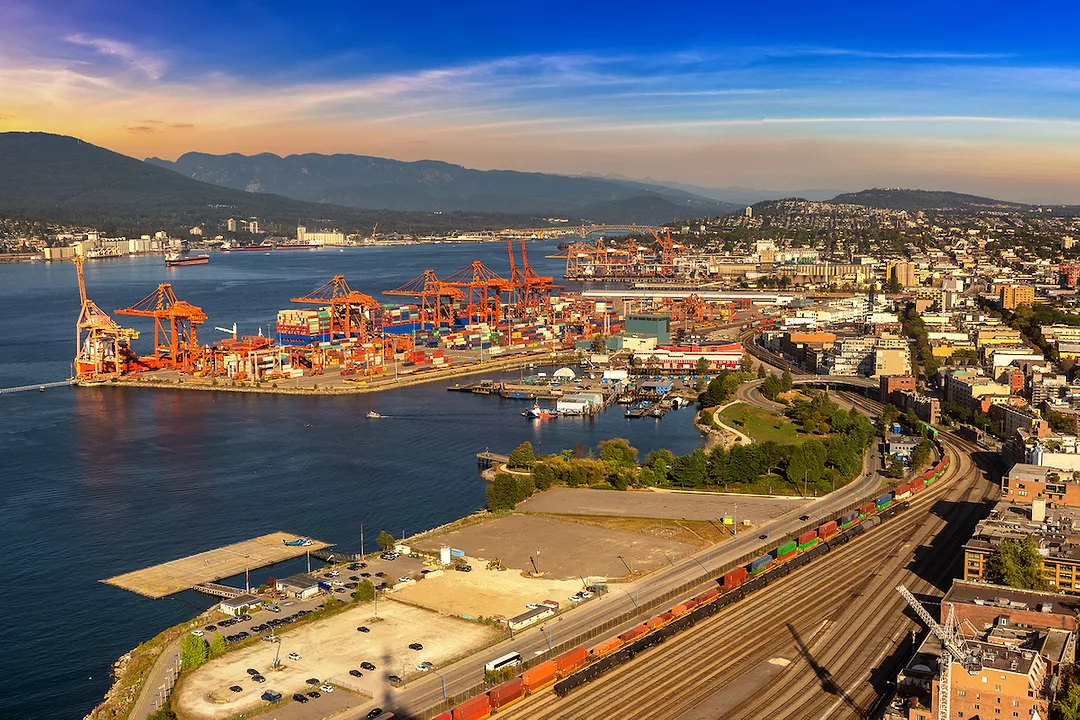 A PANORAMIC AERIAL VIEW OF THE PORT OF CANADA CAN BE SEEN AT SUNSET.