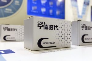 THREE WHITE BOXES WITH CAR BATTERIES CAN BE SEEN ON A WHITE TABLE. ON THE BOXES, THE CATL LOGO CAN BE SEEN ABOVE CHINESE WRITING.