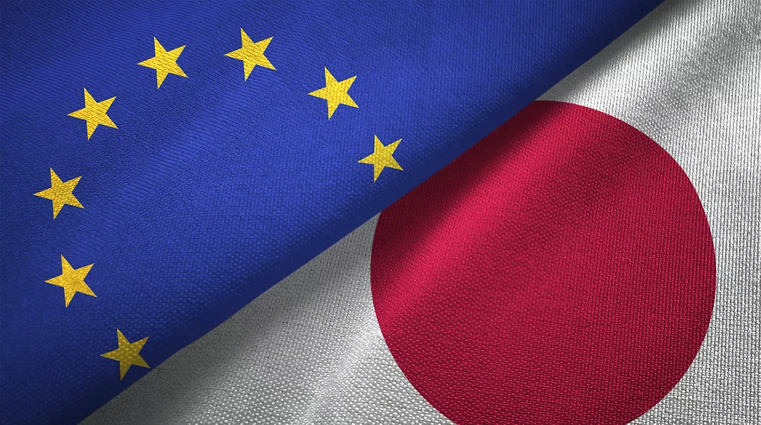 THE EUROPEAN AND JAPANESE FLAGS ARE PICTURED NEXT TO EACH OTHER WITH A DIAGONAL LINE GOING FROM THE TOP RIGHT CORNER TO THE BOTTOM LEFT CORNER OF THE PICTURE CUTTING THEM PERFECTLY IN HALF.