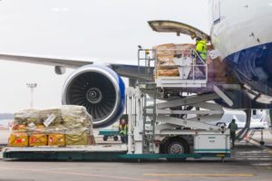 FREIGHT IS LIFTED ONTO THE OPEN HATCH OF A CARGO PLANE