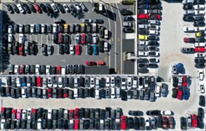 AN AERIAL VIEW OF NEW AND USED CARS CAN BE SEEN IN THE PARKING LOT OF A DEALERSHIP.