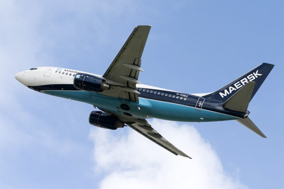 A WHITE, DARK BLUE AND LIGHT BLUE MAERSK LABELLED AIRPLANE IS FLYING THROUGH THE SKY.
