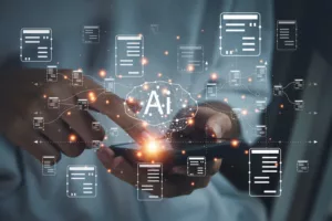 DIGITAL RENDERINGS OF CHARTS AND A BRAIN WITH THE LETTERS "AI" APPEAR ABOVE A CELL PHONE BEING HELD IN A PAIR OF HANDS.
