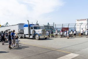 DOCK WORKERS HOLD UP SIGNS OF PROTEST TO A TRUCK AT A PORT