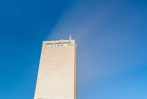 SUNLIGHT REFLECTS OFF THE GOLD-TINTED GLASS OF A HANWHA SKYSCRAPER.