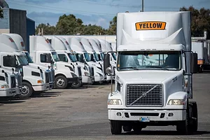 A FLEET OF TRUCKS BEARING THE YELLOW LOGO