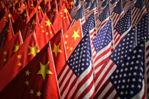 MANY AMERICAN AND CHINESE FLAGS ARE GROUPED TOGETHER. AMERICAN FLAGS ARE ON THE RIGHT. CHINESE FLAGS ARE ON THE LEFT.