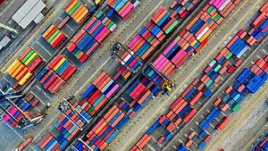 BRIGHTLY COLORED SHIPPING CONTAINERS ON A DOCK, SEEN FROM ABOVE