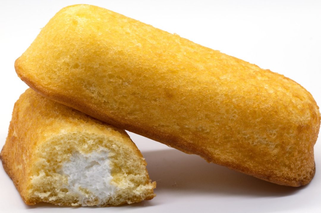 TWO TWINKIE BARS, ONE WITH A BITE OUT SHOWING THE FILLING.