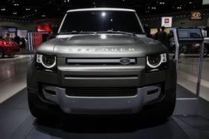 THE FRONT VIEW OF A LAND ROVER DEFENDER 90 SUV THAT IS BEING DISPLAYED IN A ROOM.