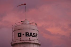 BASF IS WRITTEN ON THE SIDE OF A TOWER AT A CHEMICAL PLANT.