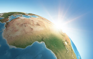 THE SUN IS SHINING OVER A DETAILED VIEW OF PLANET EARTH WITH A FOCUS ON AFRICA.