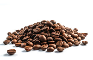 A PILE OF COFFEE BEANS SITS IN A COMPLETELY WHITE SPACE.