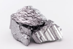 TWO PIECES OF THE RARE EARTH METAL ERBIUM ARE SITTING ON TOP OF EACH OTHER.