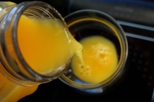 AN AERIAL VIEW OF ORANGE JUICE BEING POURED INTO A GLASS.