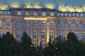 THE EXTERIOR OF A BUILDING THAT HAS THE HAPAG-LLOYD LOGO ON IT CAN BE SEEN AT NIGHT.