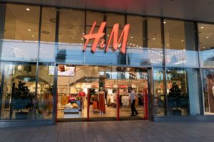 AN OUTSIDE VIEW OF A BRIGHTLY LIT H&M STOREFRONT