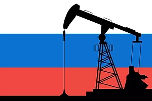 A DRAWING OF A SILHOUETTE OF AN OIL PUMP SITS I FRONT OF THE RUSSIAN FLAG.