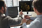 DATA SCIENCE MACHINE LEARNING ML ARTIFICIAL INTELLIGENCE AI iStock-Arsenii Palivoda-1455300089.jpg TWO WORKERS DISCUSS DATA SHOWN ON COMPUTER SCREENS