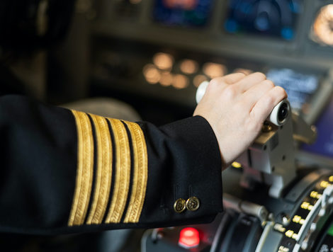 AN AIRPLANE PILOT'S HAND IS PLACED ON A PLANE ENGINE CONTROL STICK.