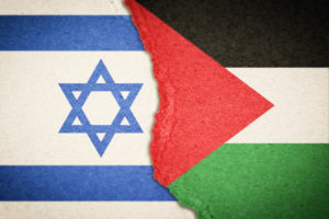 THE ISRAELI AND PALESTINIAN FLAGS APPEAR TO BE DIVIDED DOWN THE MIDDLE OF THE IMAGE. ISRAEL IS ON THE LEFT. PALESTINE IS ON THE RIGHT.