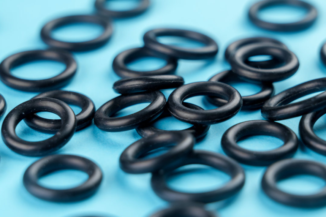 SMALL CIRCULAR RUBBER GASKETS OVER A BLUE BACKGROUND.