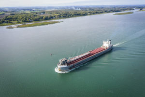 A CARGO SHIP NEAR THE PORT OF MONTREAL TRAVELS ON THE ST. LAWRENCE SEAWAY.