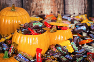 THREE DECORATIVE PUMPKINS ARE FILLED WITH AN ASSORTMENT OF CANDY AND ARE SURROUNDED BY MARS PRODUCTS.