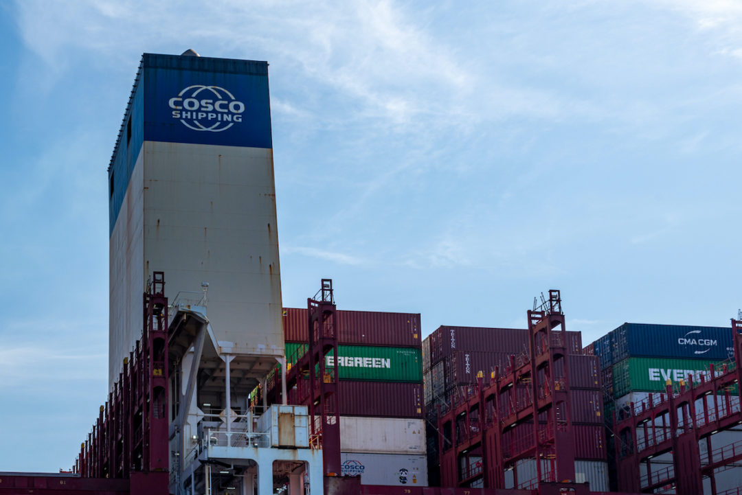 CLOSE UP OF THE SUPERSTRUCTURE OF A CONTAINER SHIP WITH THE COSCO SHIPPING LOGO ON IT.