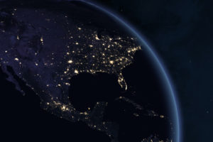 SPACE VIEW OF THE U.S. AND LATIN AMERICA AT NIGHT. SOME PARTS OF THE GLOBE ARE ILLUMINATED BY SMALL LIGHTS.