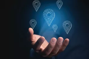 AN OUTSTRETCHED HAND APPEARS TO BE CATCHING GEOLOCATION ICONS