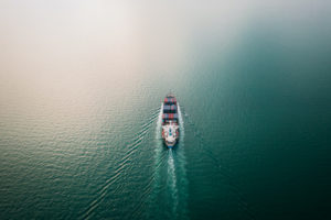 A WIDE-SHOT, AERIAL VIEW OF A CONTAINER SHIP AT SEA.