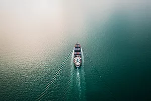 A WIDE-SHOT, AERIAL VIEW OF A CONTAINER SHIP AT SEA.