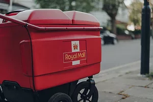 A RED DELIVERY TROLL ON THE STREETS OF LONDON HAS THE ROYAL MAIL LOGO ON IT.