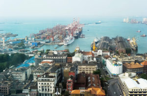 VIEW OF APARTMENTS AND BUILDINGS NEAR THE PORT OF COLOMBO IN SRI LANKA. A SHIP APPEARS TO BE SAILING AWAY FROM THE PORT.